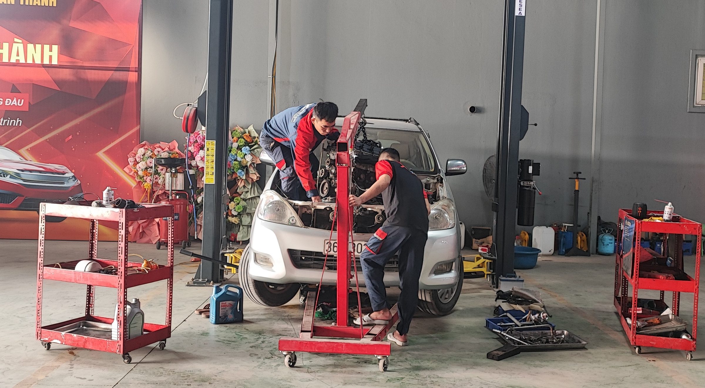 Kỹ thuật viên làm việc tại khu vực khoang động cơ của xe